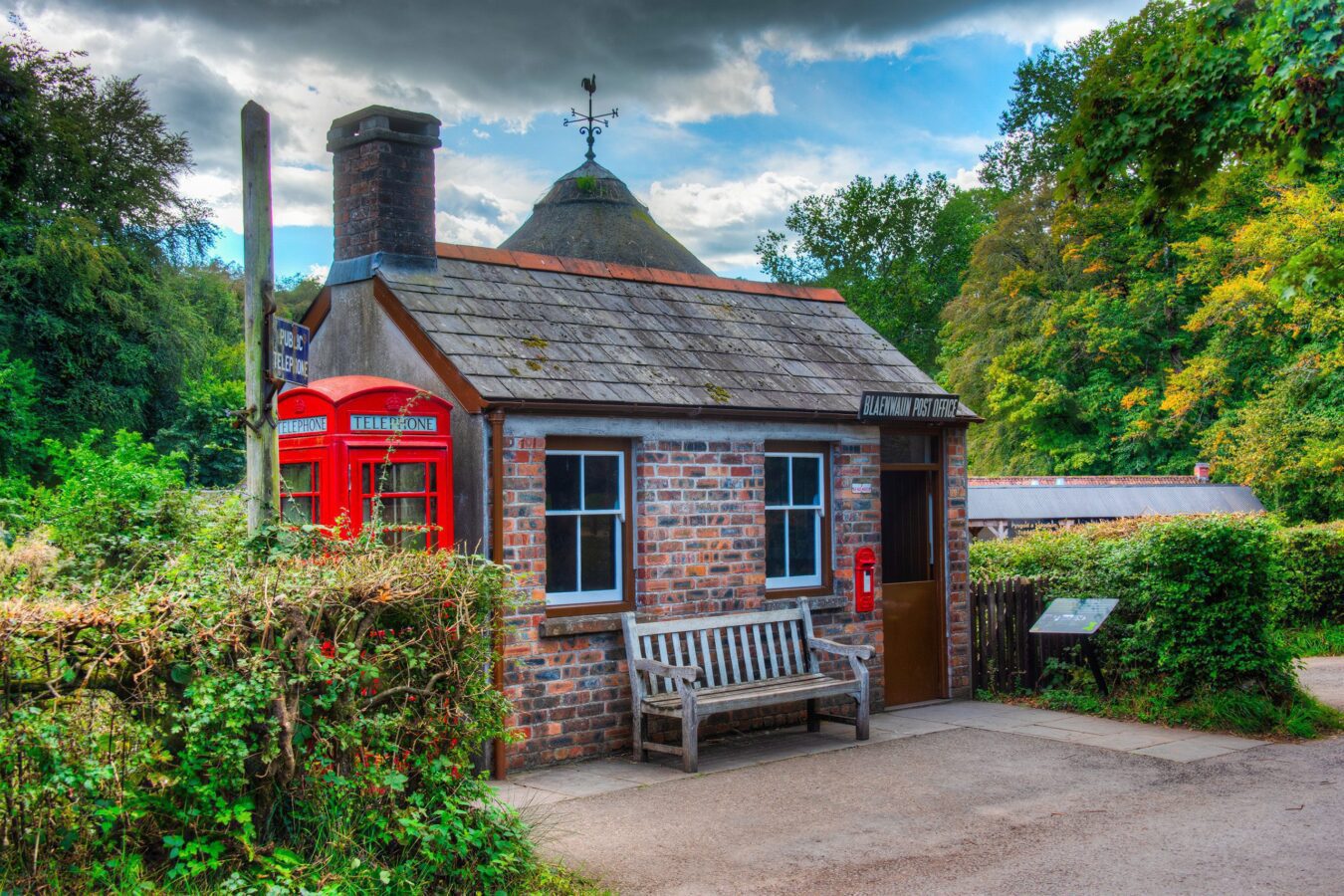 Exterior view of St. Fagans National Museum of History, a renowned open-air museum in Wales, surrounded by lush greenery and historic buildings.
