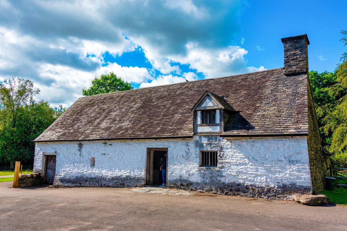 Exterior view of St. Fagans National Museum of History, a renowned open-air museum in Wales, surrounded by lush greenery and historic buildings.