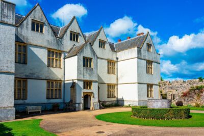 Exterior view of St. Fagans National Museum of History, a renowned open-air museum in Wales, surrounded by lush greenery and historic buildings.