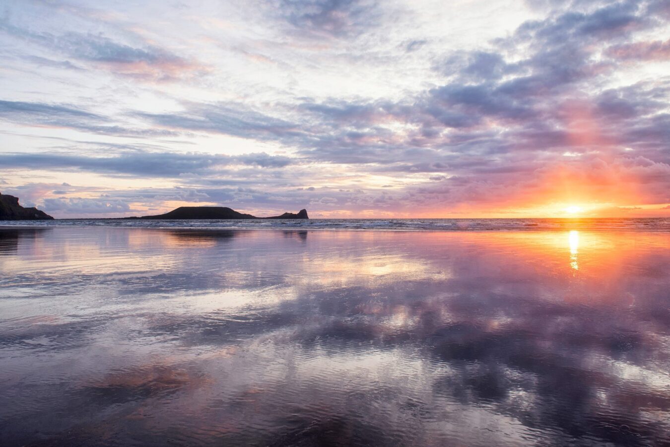 Landscape image of Rhossili Beach, South Wales at sunset